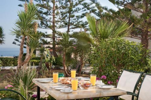 een tafel met eten erop met palmbomen bij Panorama-Seaview Studios & Apartments in Chersonissos