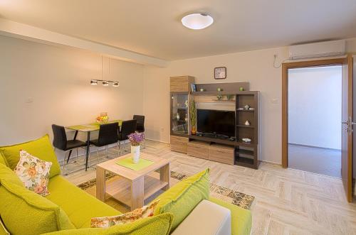 a living room with a couch and a tv and a table at Apartment Mistovic in Kotor