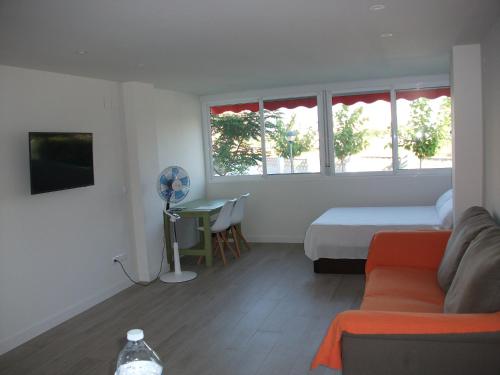 BenimagrellにあるPlaya de San Juan Apartmentのベッドルーム1室(ベッド1台、ソファ、テーブル付)