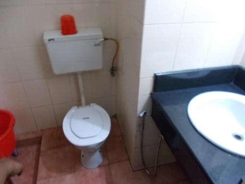 a bathroom with a white toilet and a sink at Biju's Tourist Home in Cochin