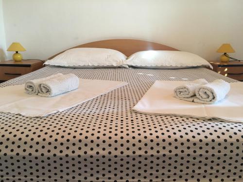 zwei Betten mit Handtüchern und Kissen darauf in der Unterkunft Apartment Floral in Brodarica