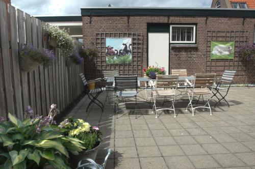 a patio with chairs and tables and a fence at B&B Posthoorn in Hoorn