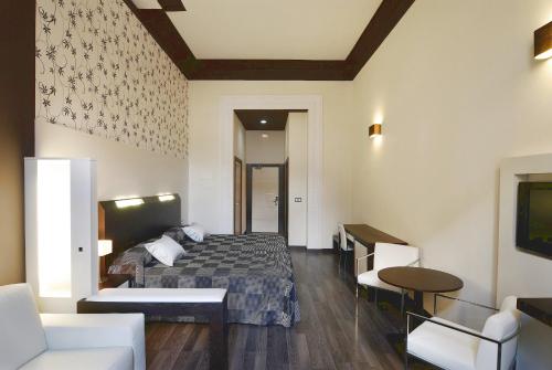 Habitación de hotel con cama y sofá en Alhambra Suites en Madrid