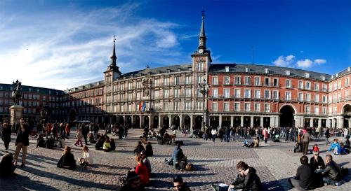 a group of people sitting in front of a large building at Alhambra Suites in Madrid