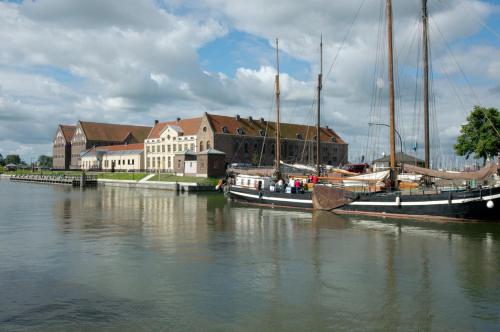 two boats are docked in a river near a building at B&B Posthoorn in Hoorn
