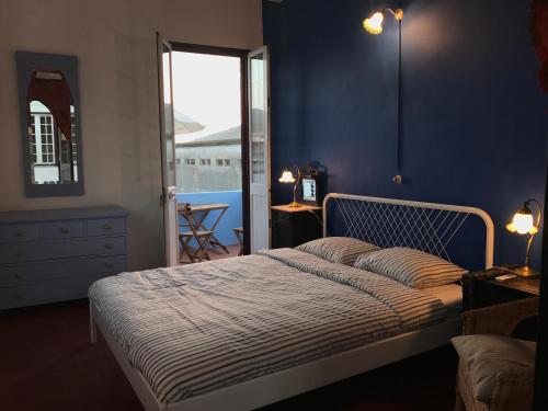 a bedroom with a bed with a blue wall at Pátio das Andorinhas in Ferreira do Alentejo