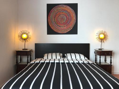 a bedroom with a black and white bed with two lamps at Pátio das Andorinhas in Ferreira do Alentejo