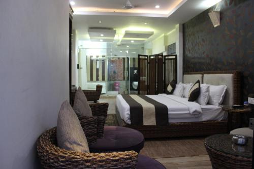 une chambre d'hôtel avec un lit et une chaise dans l'établissement Ganga Exotica, à Haridwar