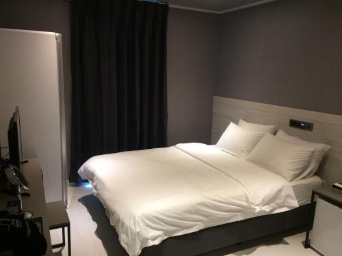 a large white bed in a hotel room at Hotel Iam in Suncheon