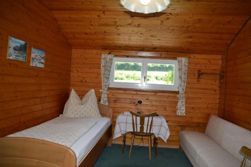 Piccola camera con letto, divano e finestra. di Haus Kärnten a Altossiach