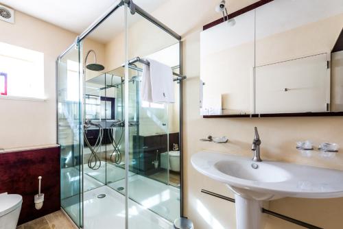 baño con cabina de ducha de cristal y lavamanos en Hôtel-Restaurant le Château de Besseuil, Mâcon Nord - Teritoria, en Clessé
