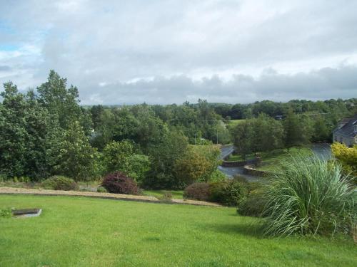 a view of a park with a river and trees at Nephin Lodge in Westport