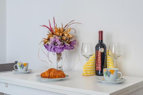 a table with two plates of croissants and a bottle of wine at Chris's condo in Split