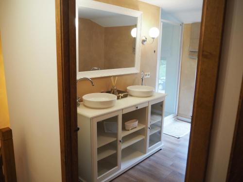 a bathroom with two sinks and a large mirror at La Balade du Ricochet in Tenneville