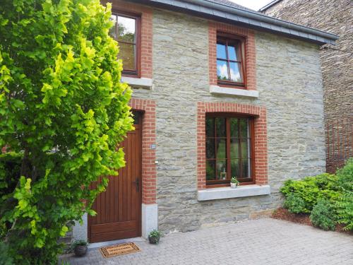 a brick house with a wooden door and windows at La Balade du Ricochet in Tenneville
