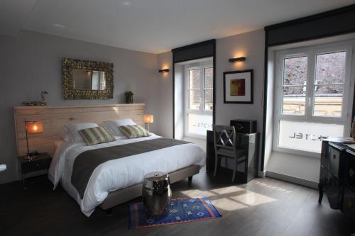 - une chambre avec un grand lit et 2 fenêtres dans l'établissement LOGIS Hotel-Restaurant Le Relais d'Aligre, à Châteauneuf-en-Thymerais