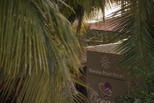 a palm tree with a sign in front of a building at Mamba Point Hotel in Monrovia
