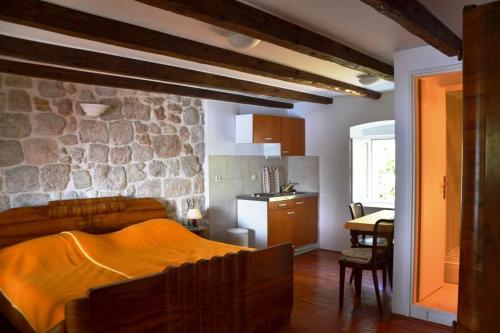 - une chambre avec un lit et un mur en pierre dans l'établissement Dubrovnik Stone House, à Dubrovnik