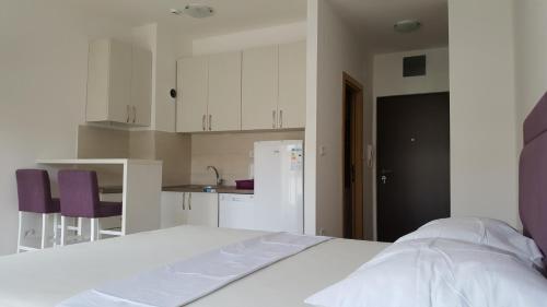 a bedroom with a white bed and a kitchen at Zebra in Podgorica