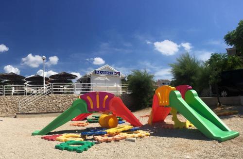 a playground with three play equipment in the sand at Apartments Matkovic in Vir