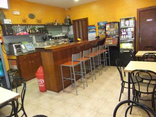 um restaurante com um bar com mesas e cadeiras em Pensió L'Estada em Sant Joan les Fonts