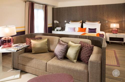 a living room with a couch and a bed at Hôtel de Paris Saint-Tropez in Saint-Tropez
