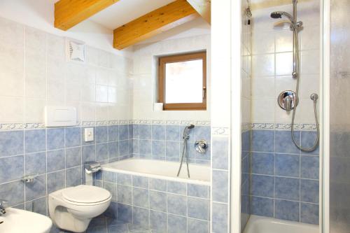 a bathroom with a tub and a toilet and a sink at Hotel Jolanda in San Martino di Castrozza