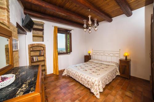 a bedroom with a bed and a chandelier at B&B Borgo Marano in Cupra Marittima
