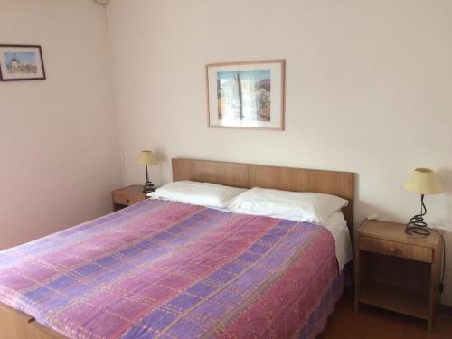 ein Schlafzimmer mit einem Bett und zwei Nachttischen mit Lampen in der Unterkunft Al Pontesel in Garda