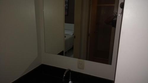 ein Badezimmer mit Spiegel und Waschbecken in der Unterkunft Aldeia das Águas Barrakana flats in Nossa Senhora das Dores