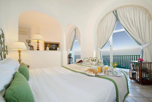 a bedroom with a bed with a table with food on it at Hotel Caesar Augustus in Anacapri