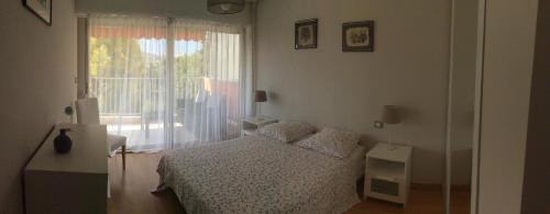 une chambre avec un lit et une grande fenêtre dans l'établissement Parouquine, à Antibes