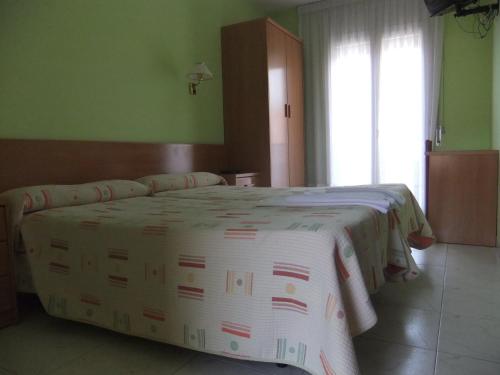 a bedroom with a large bed in a room at Pensió L'Estada in Sant Joan les Fonts