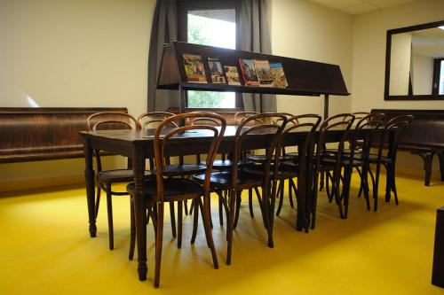 
a dining room table with chairs and a television at Hostel Bruegel in Brussels
