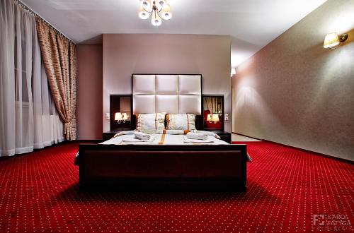 Habitación de hotel con cama y alfombra roja en Szafranowy Dwór en Strawczyn