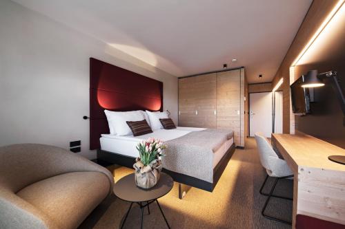a hotel room with a bed and two chairs at Rikli Balance Hotel – Sava Hotels & Resorts in Bled