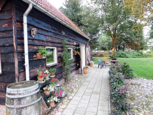 une maison en bois avec des plantes sur son côté dans l'établissement mekelermeer, à Geesbrug