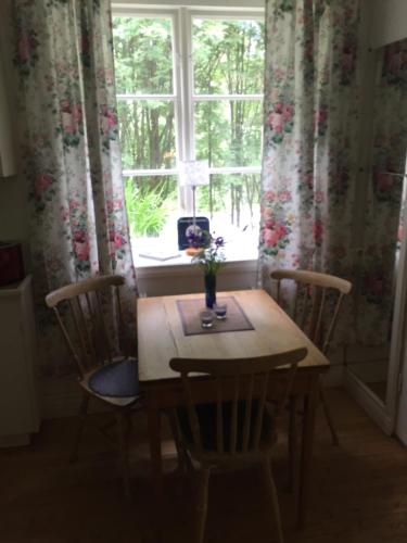 a dining room table with chairs and a window at Domsjö Apartment in Örnsköldsvik