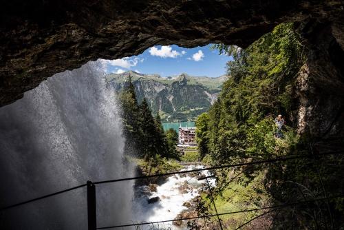 een uitzicht op een waterval vanuit een grot bij Grandhotel Giessbach in Brienz