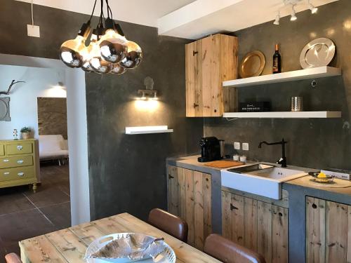 a kitchen with wooden cabinets and a wooden table at Azeite de Marvão, Olivoturismo casa Mestre do Lagar in Marvão