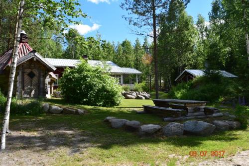 a backyard with a picnic table and a house at Lomakoti Tuulensuoja in Kärväsjärvi