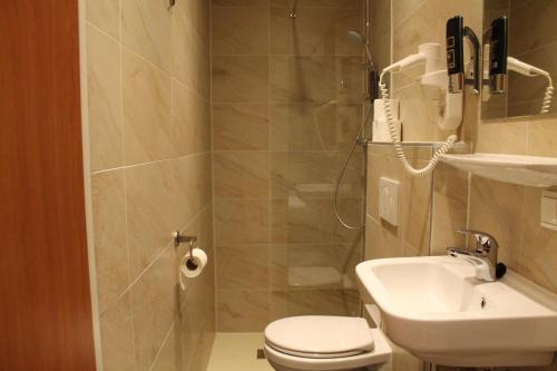 y baño con ducha, aseo y lavamanos. en Blossoms City Hotel, en Ámsterdam