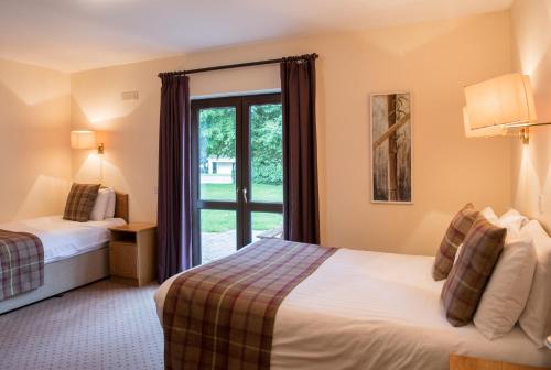 a hotel room with two beds and a window at Castlerosse Park Resort Holiday Homes in Killarney