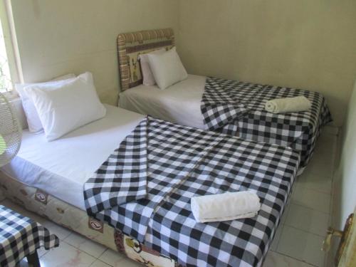 two beds sitting next to each other in a room at ESA di Kubu Homestay in Singaraja