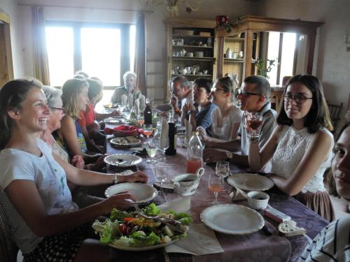 a group of people sitting around a table eating at Pontet-Fronzèle agrotourisme ecologique, maison d'hôtes & Spa in Lagorce