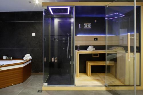 a glass shower in a bathroom with a table at Medi Terre Boutique Hotel - By Saida Hotels in Netanya