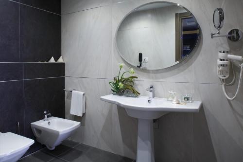 a bathroom with a sink and a mirror at Medi Terre Boutique Hotel - By Saida Hotels in Netanya