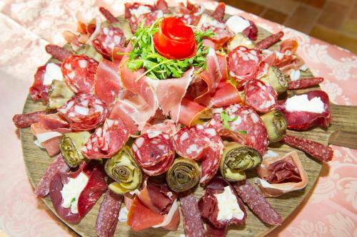 a plate of meat and vegetables on a table at Fattoria La Principina Hotel & Congress in Principina Terra