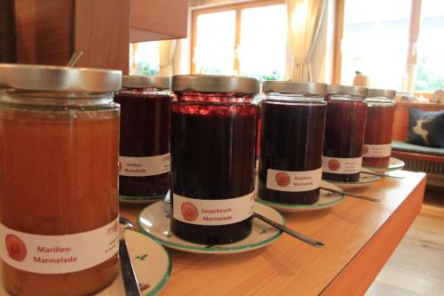 a row of jars of jam sitting on a table at moser-HOCHKÖNIG Genuss Wirtshaus Hotel in Maria Alm am Steinernen Meer