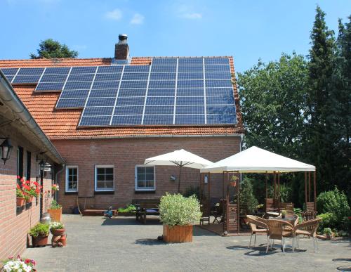 ein Haus mit vielen Sonnenkollektoren auf dem Dach in der Unterkunft Bed and Breakfast Am Schwatten Berg in Heek